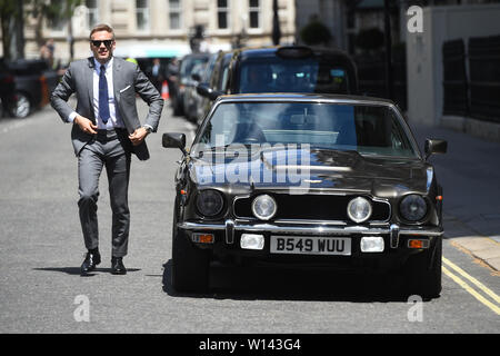 Une doublure se trouve à côté de l'Aston Martin que le tournage pour le prochain Bond film prend place sur le Mall à Londres. La encore les Projet sans titre a été le tournage en Jamaïque et à Pinewood Studios mais le compte Twitter officiel de 007 a confirmé le tournage est maintenant un film d'espionnage dans la capitale. Banque D'Images