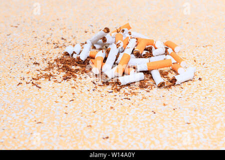 Cigarettes Pile cassée sur fond jaune table parquet mosaïque. soins de santé concept arrêter de fumer. Banque D'Images