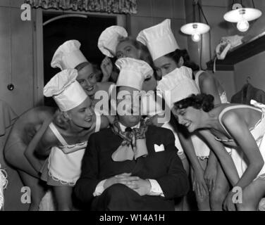 Les femmes dans les années 1950. Un groupe de jeunes femmes habillées en costumes de scène comme chefs ou serveuses. L'homme au milieu a l'air heureux d'être entouré par les beautés. Suède 1952. Kristoffersson ref 33K-2 Banque D'Images