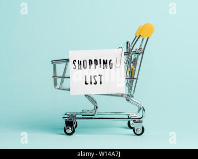 Panier Liste d'achat et de texte sur du papier blanc liste des notes. Liste de magasinage concept sur fond bleu. Banque D'Images
