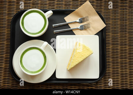 Deux tasses de thé Matcha Latte avec un morceau de gâteau à la citrouille sur un plateau Banque D'Images