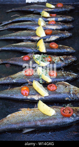 Poissons l'alimentation de rue sur le gril avec citron et herbes ligne poissons tomate Banque D'Images