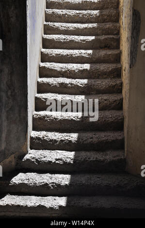 Escalier étroit avec old weathered escaliers la moitié du soleil à partir de la porte d'en haut Banque D'Images