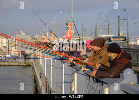 L'accent sur les pêcheurs sur le pont de Galata est allumé par fin d'après-midi. Salon de Karakoy apparaissent dans l'arrière-plan. Istanbul, Turquie Banque D'Images