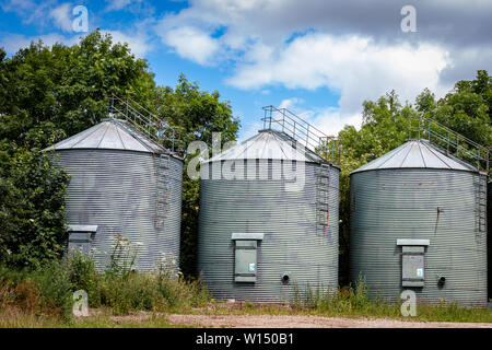 Une rangée de métal vert Silo de stockage de céréales sur les réservoirs d'un Rural Farm dans le Derbyshire UK Banque D'Images