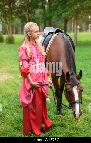 La Russie, Saint-Pétersbourg, 08.13.2016. Belle fille avec son cheval andalou et magnifique coucher du soleil chaud dans la forêt d'automne Banque D'Images