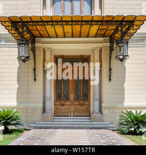 Décorées de meubles anciens en bois porte dans un mur de briques en pierre, parasol et deux lanternes, façade de Palais Abdine, Le Caire, Egypte Banque D'Images