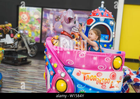 La Russie, Saint-Pétersbourg, 06/22/2019. Petite fille se déplace sur le carrousel de l'enfant dans l'hypermarché Banque D'Images