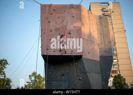 Belgrade, Serbie, 27 juin 2019 : Jeune femme active grimper sur mur d'escalade extérieur Banque D'Images