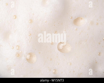 Texture mousse extreme close up comme arrière-plan. La bière ou la mousse cappucino avec bulles shoot macro. L'espace de copie pour le texte. Banque D'Images