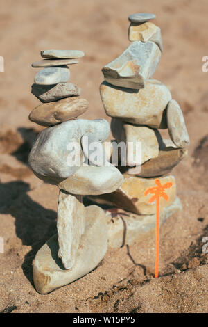 Des pierres se trouvent sur les pierres. le feng shui sur la plage. Créer un équilibre dans le sable de pierres. Banque D'Images