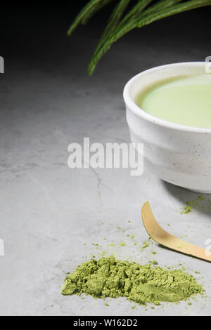 Thé vert bio matcha avec bambou cuillère dans un bol sur marbre gris. Cérémonie du thé japonais, concept copy space Banque D'Images