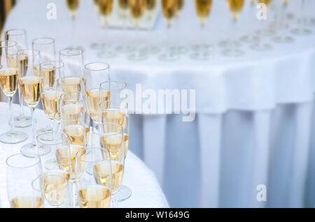 Beaucoup de verres à vin avec un champagne ou vin blanc sur la table ronde. Arrière-plan de l'alcool Banque D'Images