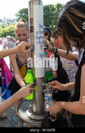 Les participants à la Gay Pride de Paris 2019 remplir leurs bouteilles d'eau au cours d'une de la journée la plus chaude de l'année. Banque D'Images