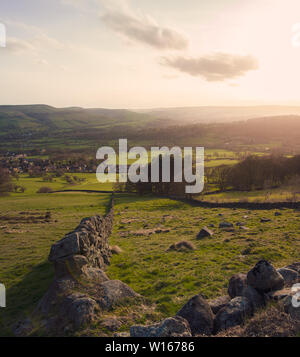 Un coucher de soleil sur l'un des nombreux murs en pierre cassée dans le Peak District National Park Banque D'Images