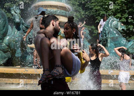 Les gens refroidir dans le Parc du Luxembourg fontaine au cours de la Gay Pride 2019 qui était sur une de la journée la plus chaude de l'année. Banque D'Images