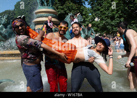 Les gens refroidir dans le Parc du Luxembourg fontaine au cours de la Gay Pride 2019 qui était sur une de la journée la plus chaude de l'année. Banque D'Images