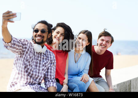 Groupe d'amis en tenant sur selfies beach tout en profitant de l'été, copy space Banque D'Images