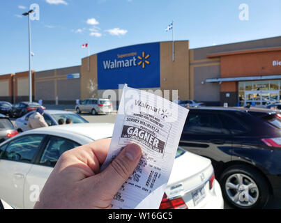 Montréal, Canada - 30 avril 2019 : Une main tenant un Walmart réception en face du magasin Walmart. Walmart est une société qui exploite de détail américain Banque D'Images