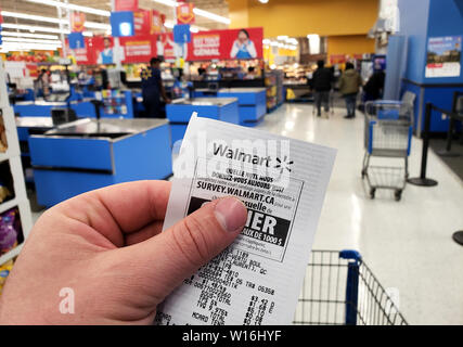 Montréal, Canada - 30 avril 2019 : Une main tenant un magasin Walmart Walmart en réception. Walmart est une société de vente au détail américaines qui exploite une chaîne Banque D'Images