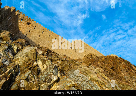 Muttrah fort mur sur la colline rocheuse avec fond de ciel bleu. Tourné à partir de ci-dessous à Muscat, Oman. Banque D'Images