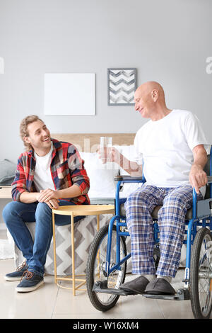 Jeune homme de visiter son père en maison de soins infirmiers Banque D'Images