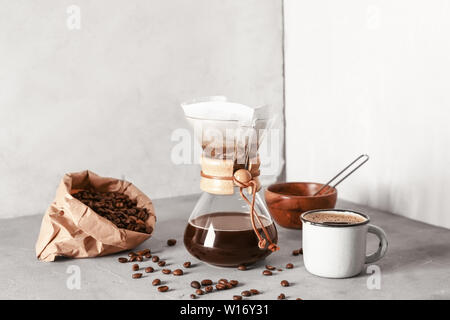 Café savoureux dans la tasse et chemex sur table gris Banque D'Images