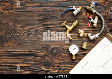 Ensemble d'éléments de plomberie avec plan de maison sur fond de bois Banque D'Images