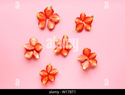 Fleurs faites de fruits rouges sur un fond de couleur fraise Banque D'Images