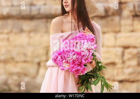 Femme avec bouquet de belles fleurs de pivoine en plein air Banque D'Images