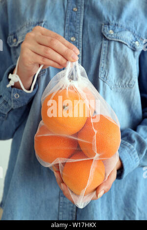 Femme avec des oranges fraîches en eco sac, closeup Banque D'Images