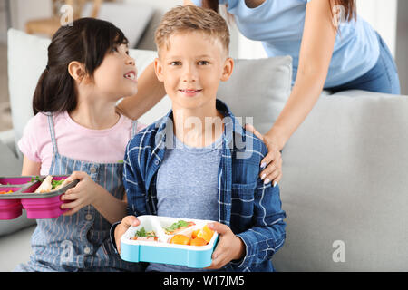 Les petits enfants avec des boîtes à lunch avant l'école Banque D'Images