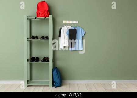 L'uniforme scolaire élégant, sac à dos et des chaussures dans la chambre Banque D'Images