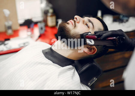 Homme assis dans un élégant salon de coiffure Banque D'Images