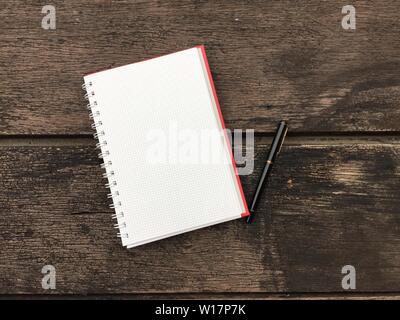 Page du bloc-notes et stylo noir sur le vieux bois avec copie espace arrière-plan du tableau. Ouvrez le bloc-notes en blanc sur une surface en bois sombre. Vue de dessus ouvrir note boo Banque D'Images