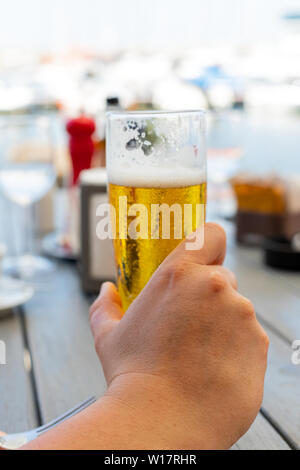 Close up photo de l'homme tenant une bière froide dans un restaurant. Banque D'Images