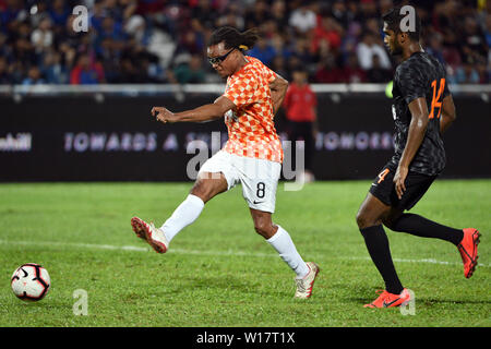 Johor Bahru, Malaisie. 30 Juin, 2019. Edgar Davids (L) de JDT Reste du Monde tire la balle pendant le match de charité amical All-Stars JDT JDT JDT et ATM entre le reste du monde à Johor Bahru, Malaisie, le 30 juin 2019. Credit : Chong Chung Voon/Xinhua/Alamy Live News Banque D'Images