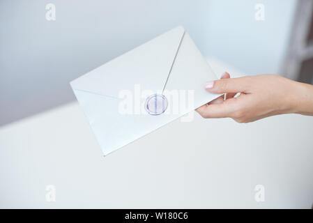 Photo en gros plan des femmes avec sceau en cire avec enveloppe d'invitation, certificat-cadeau, carte postale, carte d'invitation de mariage Banque D'Images