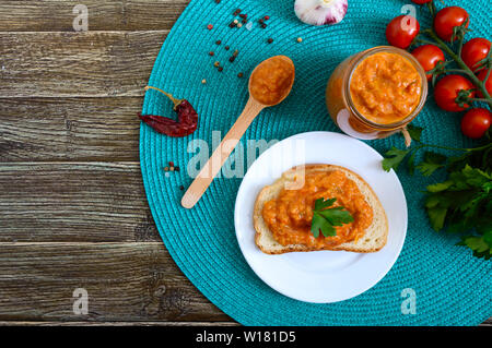 Délicieux caviar squash dans un bocal et la propagation sur les tranches de pain blanc sur la table. Le caviar fait maison avec les courgettes, l'ail, carottes, sauce tomate. Vegan Banque D'Images