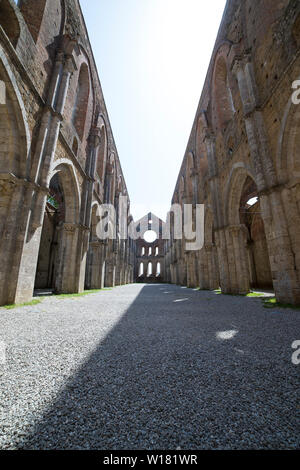 La nef centrale de l'abbaye sans toit de San Galgano, situé dans la campagne toscane, sur une journée ensoleillée. Chiusdino, Italie. Prise de vue au grand angle vertical. Banque D'Images