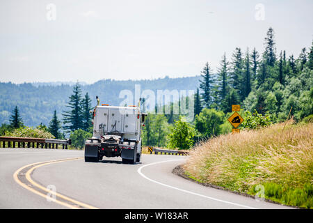Gros camion blanc de qualité industrielle populaire puissant semi classique tracteur routier avec cinquième roue de l'attelage d'exécution sur la route de montagne sinueuse avec hill et g Banque D'Images