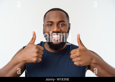 Young african american man sur fond isolé portant sport wear smiling with happy face à avec pouce vers le haut. Banque D'Images