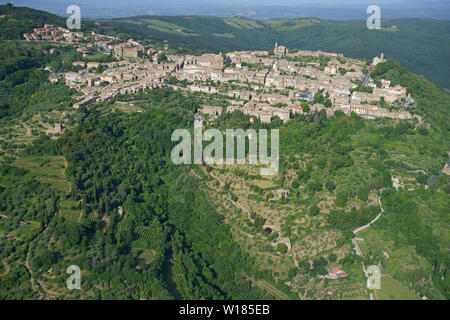 VUE AÉRIENNE. Pittoresque ville médiévale au sommet d'une colline à Val d'Orcia. Montalcino, province de Sienne, Toscane, Italie. Banque D'Images