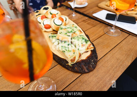 Diverses collations avec aperol spritz cocktail sur table en bois dans un café Banque D'Images