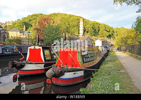 Ex-groupe Narrowboats colorés amarrés sur Rochdale Canal, Hebden Bridge Banque D'Images