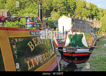 Ex-groupe Narrowboats colorés amarrés sur Rochdale Canal, Hebden Bridge Banque D'Images