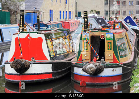 Ex-groupe Narrowboats colorés amarrés sur Rochdale Canal, Hebden Bridge Banque D'Images