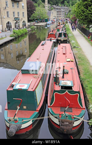 Ex-groupe Narrowboats colorés amarrés sur Rochdale Canal, Hebden Bridge Banque D'Images