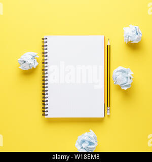 Ouvrez l'ordinateur portable vide, crayon et papier froissé sur fond jaune. Processus de création ou tentatives de création concept. Copier l'espace. Banque D'Images