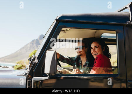 Jeune couple sympathique d'un voyage dans une voiture. Jeune femme avec son petit ami la conduite automobile. Banque D'Images